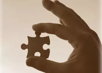 puzzle piece between finger and thumb