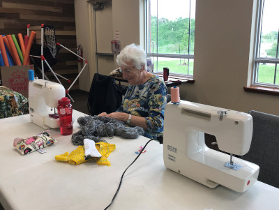 woman working at table with sewing machine